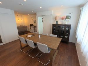 a dining room with a wooden table and chairs at Biei Central Villa 2 - Olive House in Biei
