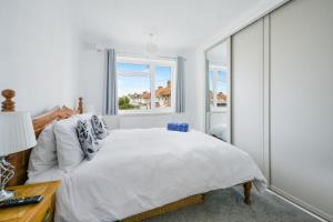 a bedroom with a bed and a window at Ocean View in Worthing, 5 bedrooms for 10, 3 Bathrooms, Hot Tub, Parking for 6, Seaview in Sompting