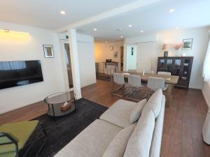 a living room with a couch and a table at Biei Central Villa 2 - Olive House in Biei