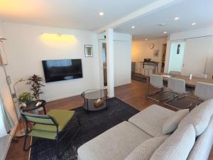 a living room with a couch and a table at Biei Central Villa 2 - Olive House in Biei