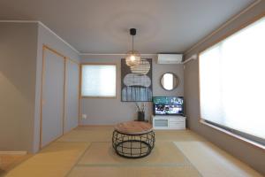 a living room with a stool and a tv at villa okinawa onna in Onna