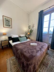 a bedroom with a large bed and a large window at Demeure d'autrefois in Passins