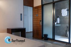 a bathroom with a shower with a glass door at Surftunnel Beach Resort in Weligama