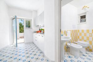 a white bathroom with a toilet and a sink at Casa Schiattarella Capri in Capri +44 photos