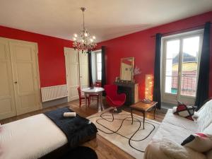 a bedroom with red walls and a chandelier at Demeure d'autrefois in Passins
