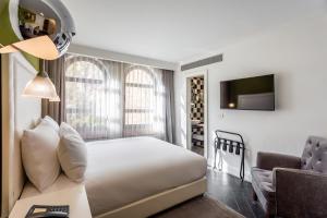 a bedroom with a bed and a tv and a chair at Jacob Harmony in Jerusalem +5 photos