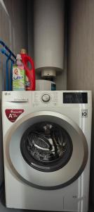 a washing machine with a red scissors on top of it at Idille Studio with Patio & Free Parking in Ventspils