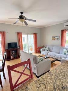 a living room with a couch and a ceiling fan at The Cove Apartments in El Francés