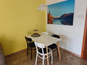 a dining room with a white table and chairs at Beautifull view at lake in Cima +12 photos