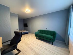 a living room with a green couch and a table at Satiksmes apartment in Jelgava