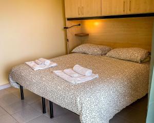 a bed with two folded towels on top of it at Maremonti in Letojanni