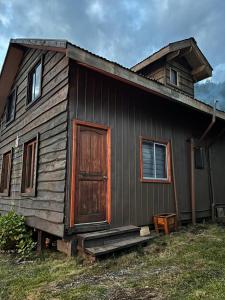 a house with a wooden door on the side of it at Cabaña Amancay Fuy in Puerto Fuy