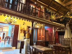 a restaurant with tables and chairs and a balcony at Villa Xiengthong Garden View Hotel in Luang Prabang +60 photos