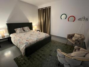 a bedroom with a bed and a chair at Loft 130m2 10pers idéal groupe famille in Marseille