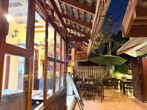 a patio with tables and chairs and an umbrella at Villa Xiengthong Garden View Hotel in Luang Prabang