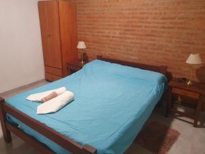 a bedroom with a blue bed with two towels on it at El Aguaribay de los Nonos in Mina Clavero +52 photos
