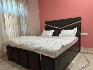 a large bed with white sheets and pillows on it at Prabhukripa Vilas Homestay in Mathura