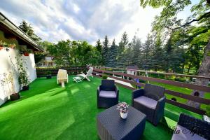 a patio with chairs and tables on a green lawn at Villa Agnes Karpacz-Miłków in Karpacz