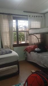 a bedroom with two bunk beds and a window at Casa centro tabo in El Tabo