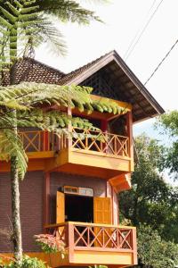 a house with a balcony and a tree at Swindo Homestay 77, Room 11 in Berastagi +25 photos