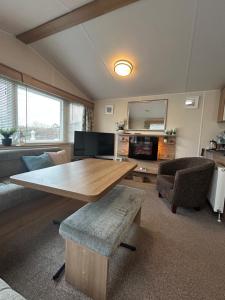 a living room with a table and a couch at Rowan 42 in New Milton
