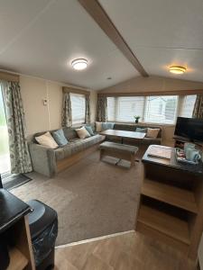 a living room with a couch and a table at Rowan 42 in New Milton