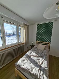 a bedroom with a bed and a large window at Villa panorama 1000 in La Chaux-de-Fonds