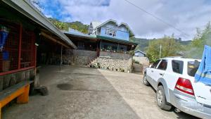a white truck parked in front of a building at Døng-elays Homestay in Maligcong