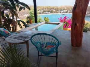 a patio with a table and chairs and a pool at Angelita's Nest House in Puerto Ángel