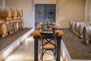 a row of wooden tables in a room with wine barrels at Cantine De Mare - Wine and Resort in Cirò Marina