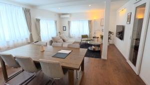 a living room with a wooden table and chairs at Biei Central Villa 2 - Olive House in Biei