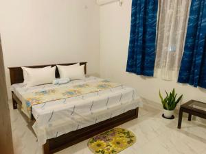 a bedroom with a bed with blue curtains at Anjana Villa in Katunayaka
