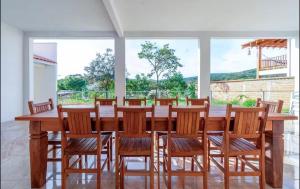 a dining room with a large wooden table and chairs at Quinta do Sol Condominium - Pirenópolis in Pirenópolis +18 photos