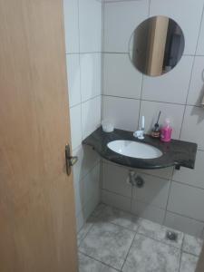 a bathroom with a sink and a mirror at Casa familiar in Vespasiano +8 photos
