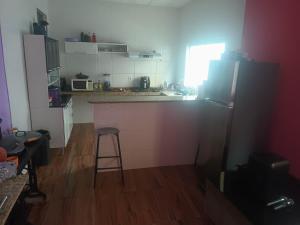 a kitchen with a counter and a stool in it at Casa familiar in Vespasiano