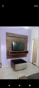 a living room with a flat screen tv on a wall at Casa familiar in Vespasiano