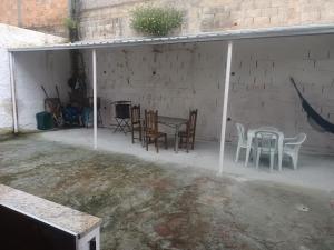 a patio with chairs and a table in a garage at Casa familiar in Vespasiano