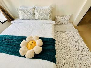 a stuffed flower on a bed in a bedroom at Comfort Home stay Private Room A Shared House in Ban Tha Khun