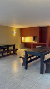 a room with two tables and benches in it at Amelia 2-4 in Villa Carlos Paz +5 photos