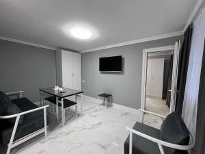 a living room with a table and chairs and a television at Hotel in Yerevan in Yerevan