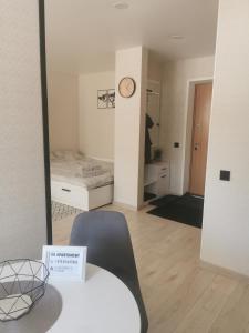 a room with a bed and a table and a mirror at SK apartament in Plungė
