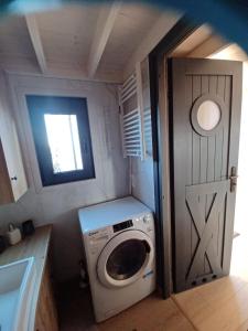 a washing machine in a small room with a door at Tiny Schwarzwald in Schopfloch