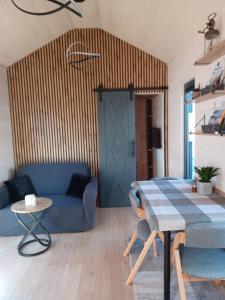 a living room with a blue couch and a table at Tiny Schwarzwald in Schopfloch