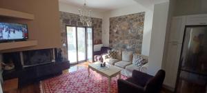 a living room with a couch and a fireplace at Stymfalia Cozy Village Guesthouse in Kartérion