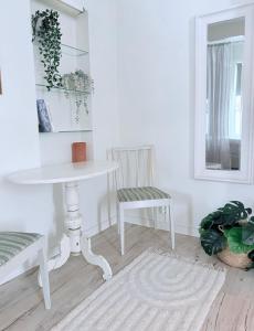 a white table and chair in a white room at Helsingebockens Fastigheter in Bollnäs