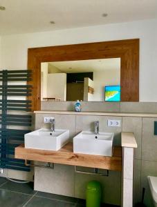 a bathroom with two sinks and a mirror at Allgäu-Chalet Kaufbeuren in Kaufbeuren +27 photos