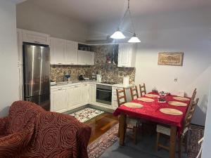 a kitchen with a table with a red table cloth at Stymfalia Cozy Village Guesthouse in Kartérion