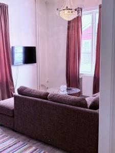 a couch in a living room with red curtains at Helsingebockens Fastigheter in Bollnäs