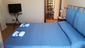 サン・レオーネにあるTerrazza mare e fioriのスリッパ2組付きの青いベッド1台