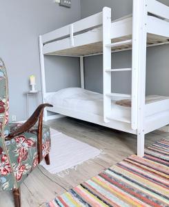 a bedroom with two bunk beds and a chair at Helsingebockens Fastigheter in Bollnäs